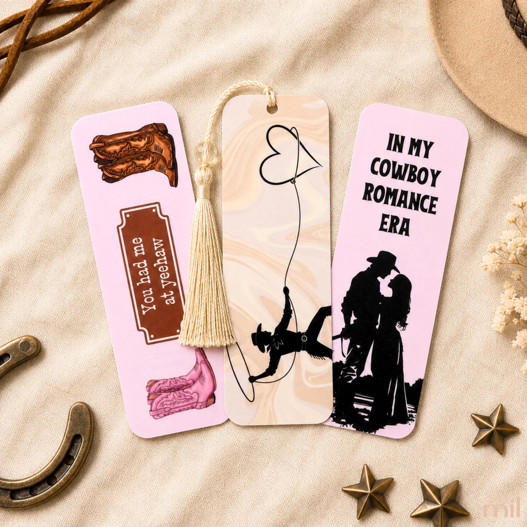Three decorative bookmark cards arranged on a beige fabric surface with rustic props. 