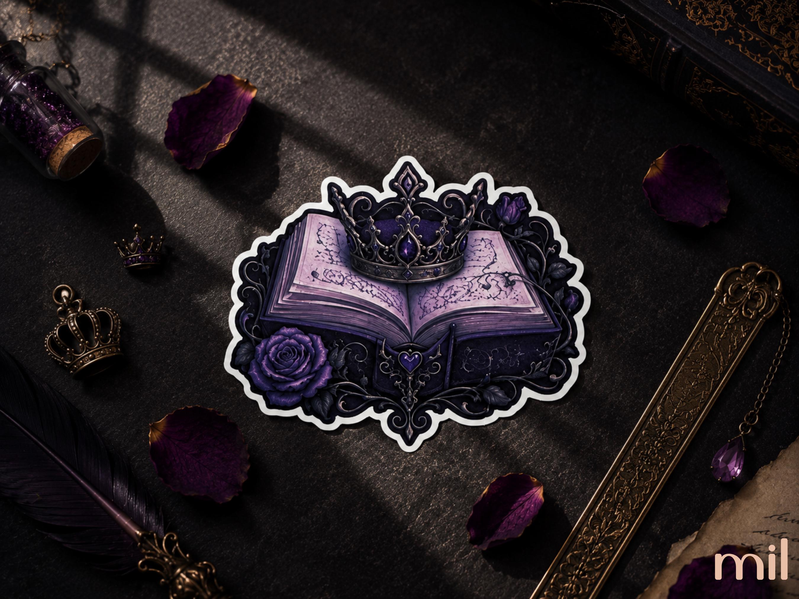 A die-cut sticker featuring an illustration of an open purple book under a crown, surrounded by a decorative black border and purple rose, displayed on a dark textured surface with gothic props.