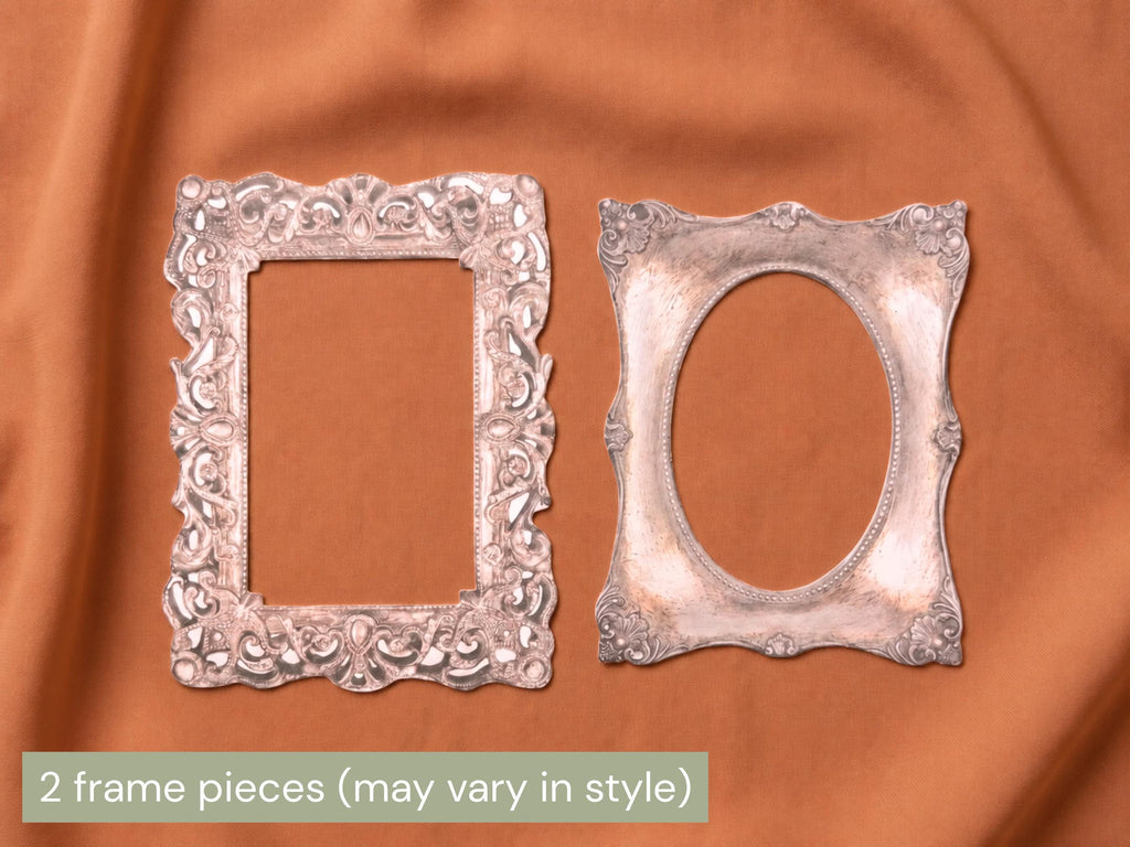 Two ornate silver picture frame pieces, one rectangular with a decorative border and one oval, displayed on a draped rust-orange fabric background. A text overlay at the bottom reads '2 frame pieces (may vary in style)'.