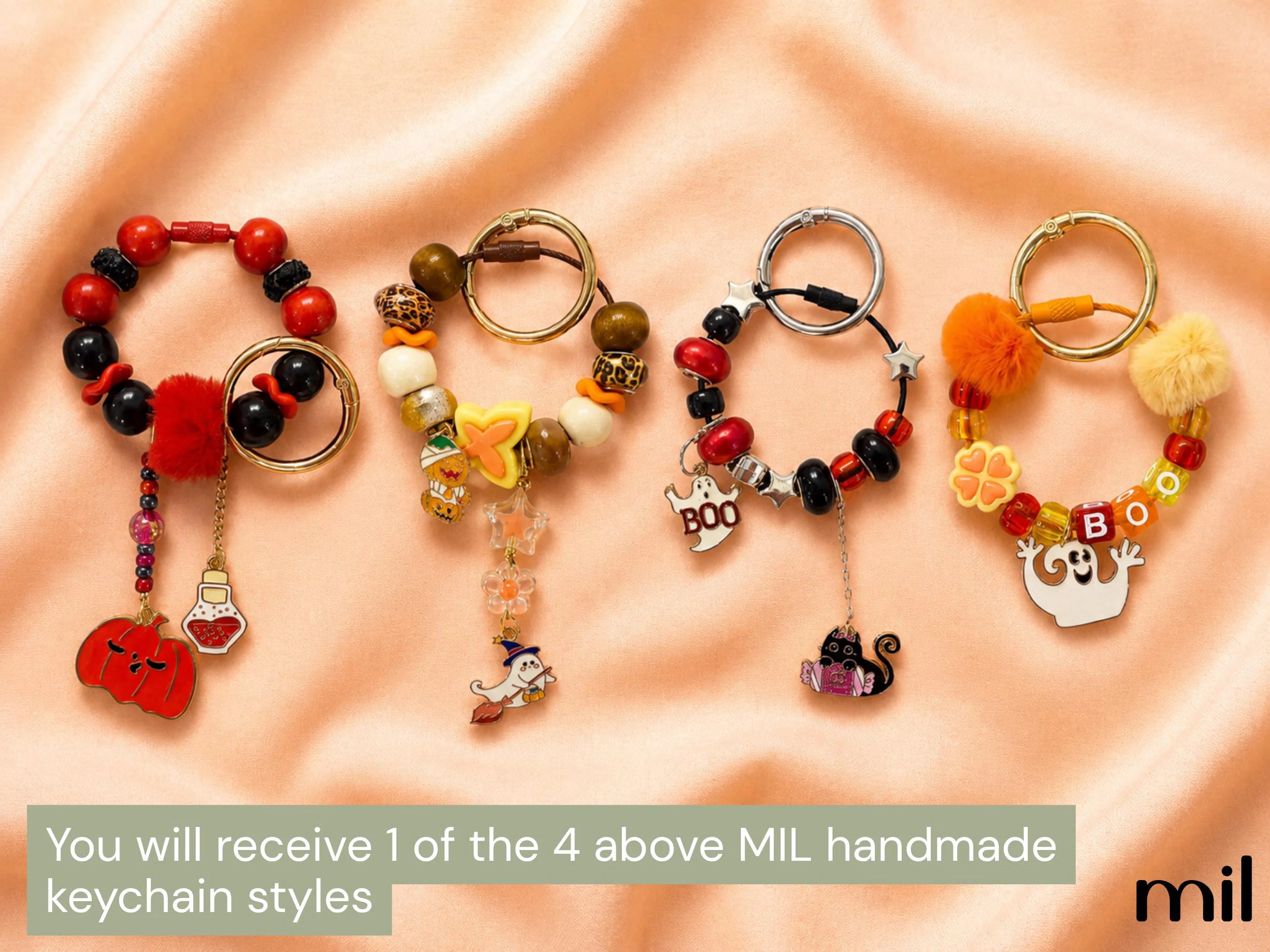 Four Halloween-themed handmade beaded keychains displayed on a peach satin background, with a text banner at the bottom stating 'You will receive 1 of the 4 above MIL handmade keychain styles' and a 'mil' logo.