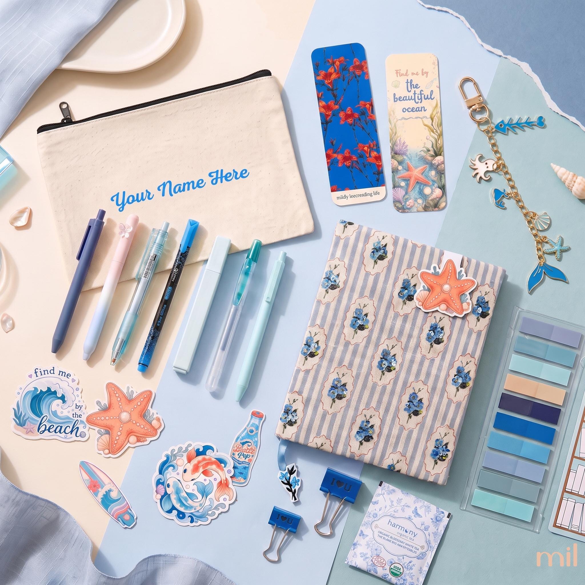 A coordinated stationery and accessory flat lay on a pastel background, including a canvas pouch with 'Your Name Here,' several pens, a striped notebook with blue floral print, bookmarks, stickers, clips, and a keychain.