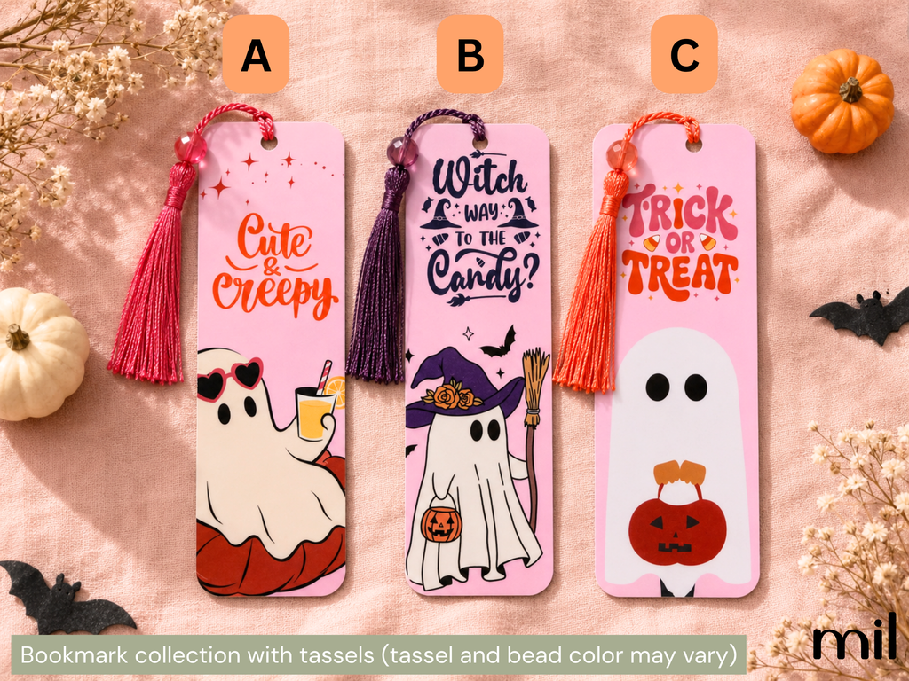 Three Halloween-themed bookmark designs displayed on a pink fabric background with decorative pumpkins, dried flowers, and black bat cutouts. The bookmarks have tassels and printed spooky graphics: a pink 'Cute & Creepy' ghost bookmark labeled A, a purple 'Witch Way to the Candy?' bookmark labeled B, and a pink 'Trick or Treat' ghost bookmark labeled C.
